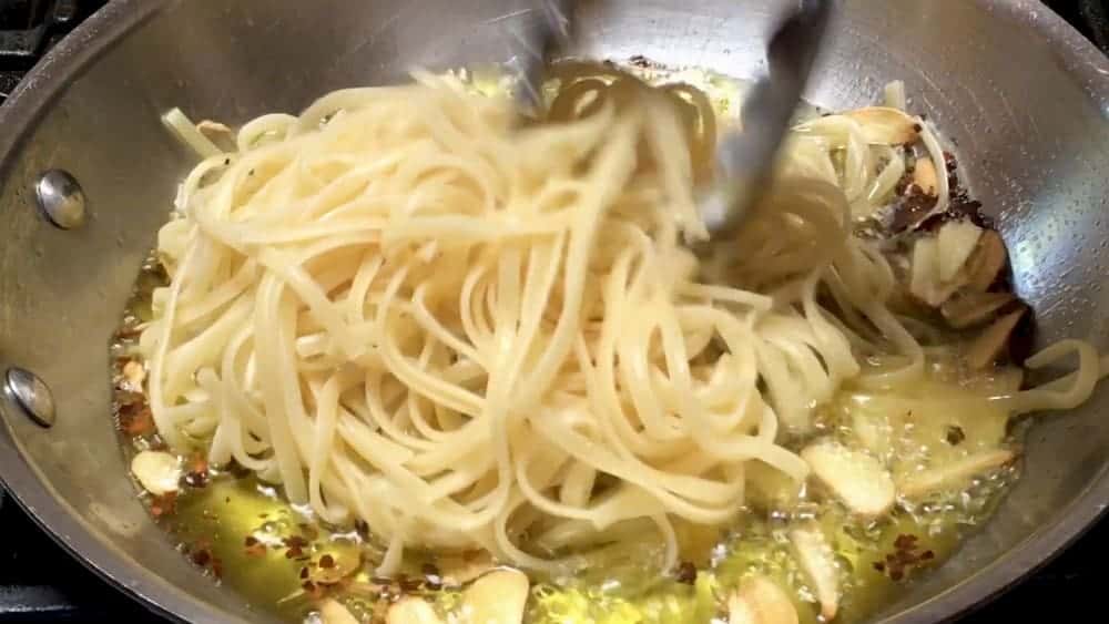 Adding Pasta to olive oil garlic and crushed red pepper