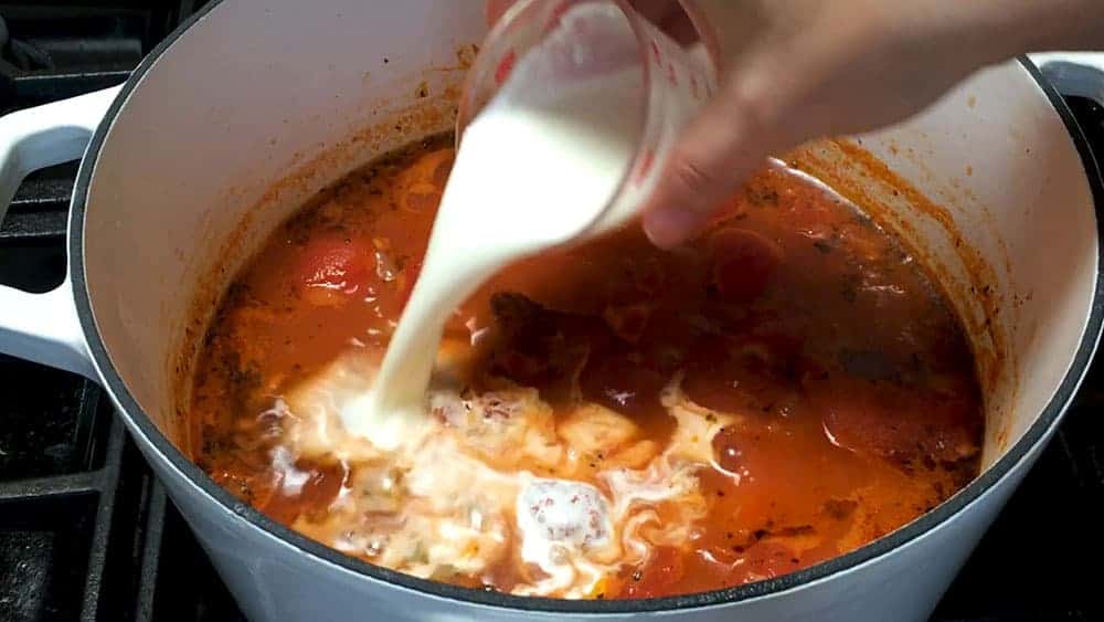 Adding cream to tomato bisque