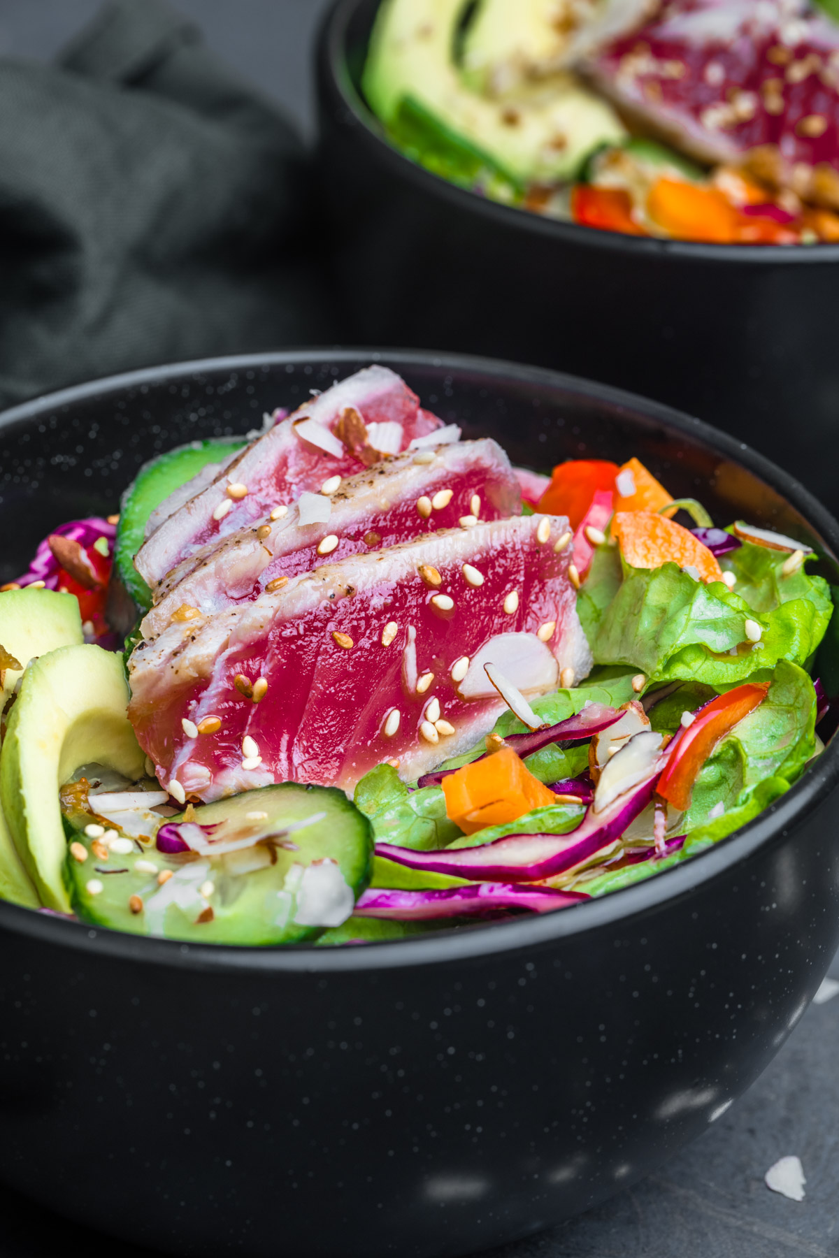 Close up shot of Ahi Tuna Salad served in a black bowl and photographed at an angle.