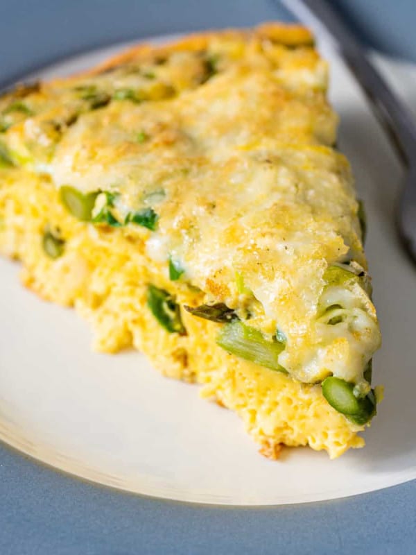 Asparagus Frittata wedge served on a white and gray plate.