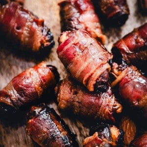 Bacon Wrapped Dates served on a wooden board.