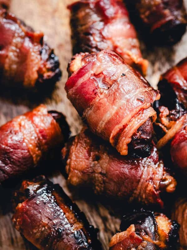 Bacon Wrapped Dates served on a wooden board.