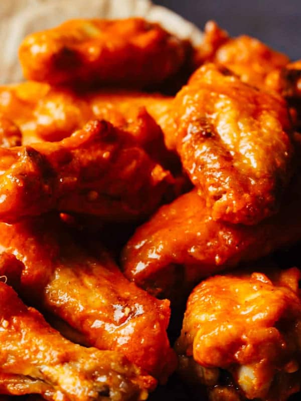 Crispy Baked Buffalo Wings served on parchment paper on a platter.