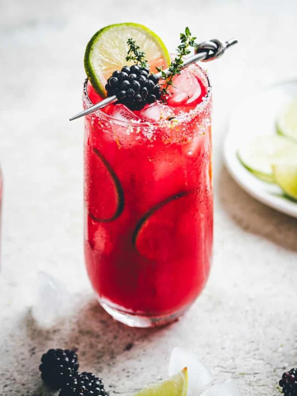 Garnished Blackberry Margarita served in a tall glass.