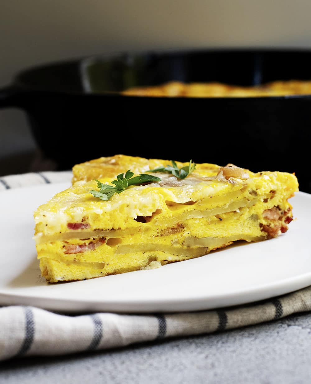 wedge of breakfast frittata served on a white plate