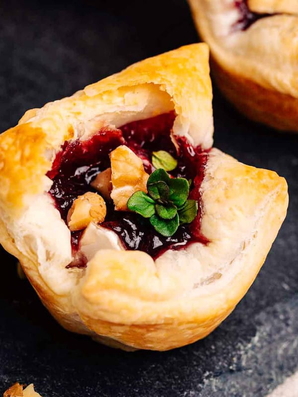 Close up photo of Brie Puff Pastry Bites on a slate serving platter.