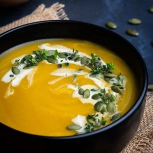 Butternut Squash Bisque served in a black bowl and photographed at an angle.