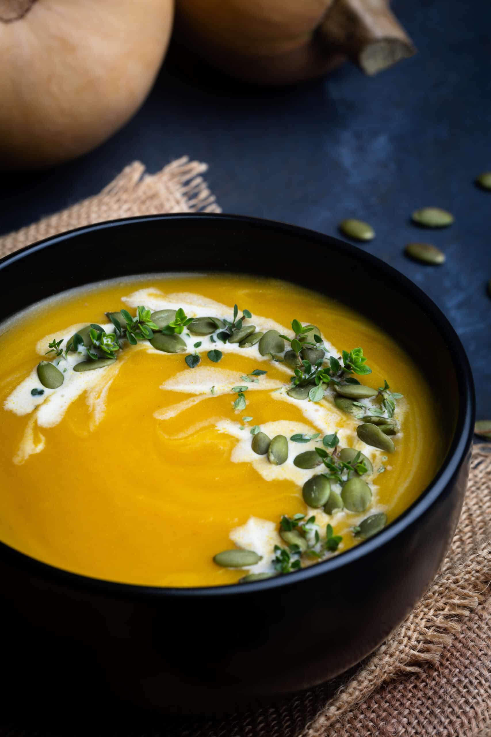 Butternut Squash Bisque served in a black bowl and photographed at an angle.