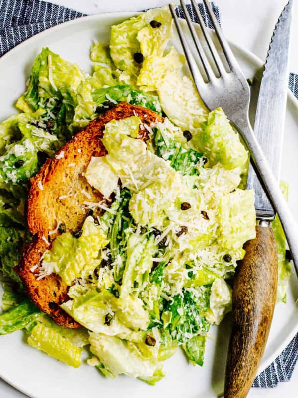 Caesar Salad served on a white plate with a knife and fork.