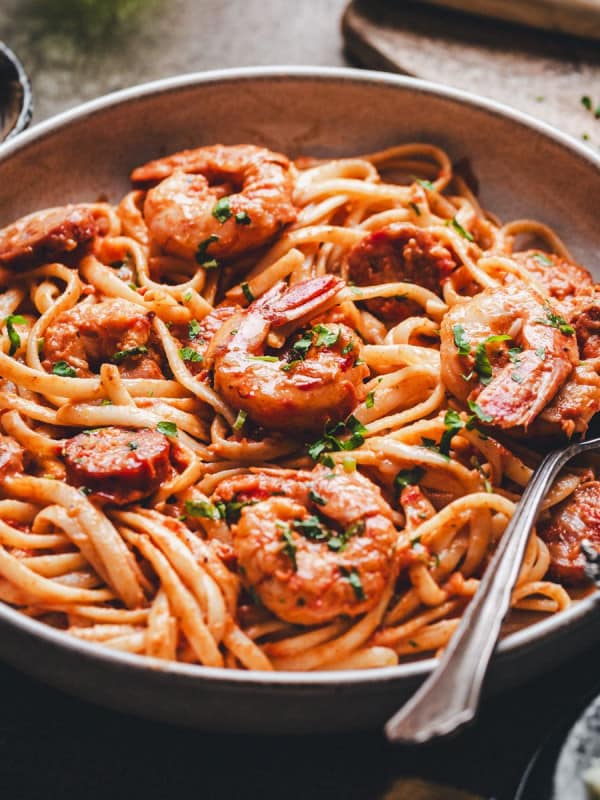 Cajun Shrimp and Sausage Pasta photographed at an angle in a light gray ceramic bowl.