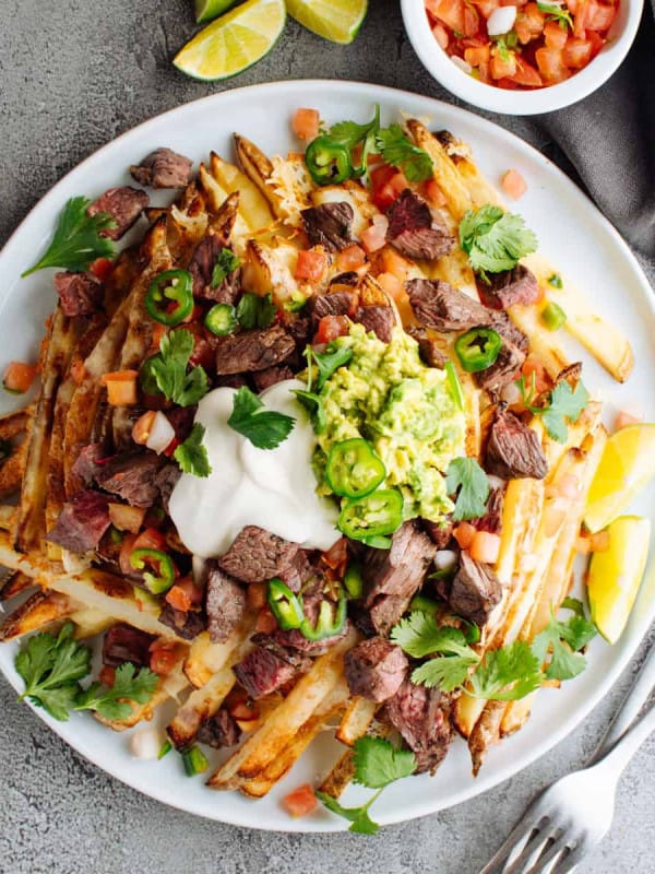 Carne Asada Fries served on a white plate photographed from above.