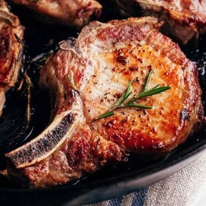 seared pork chops in a cast iron pan.