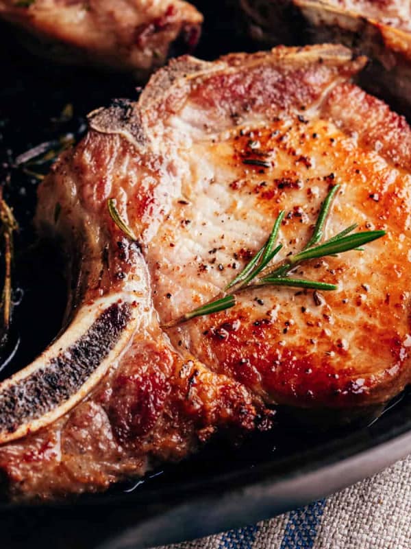 seared pork chops in a cast iron pan.