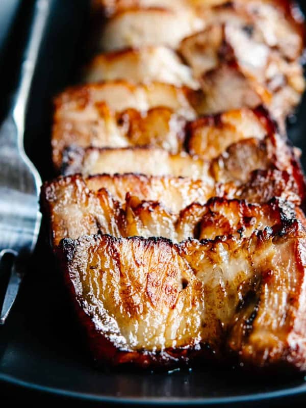 Chashu Pork served on a black plate with a serving fork