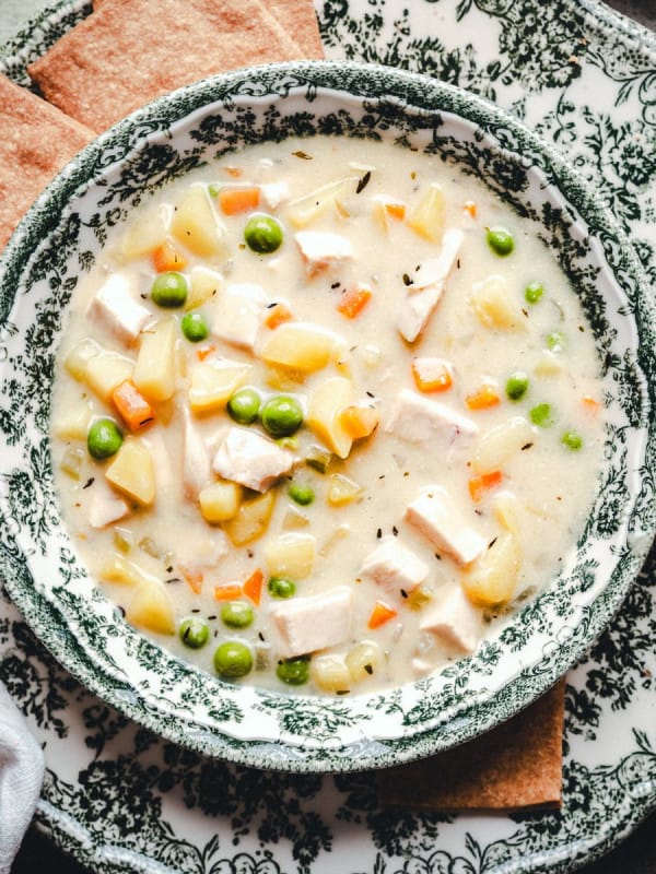 Chicken Pot Pie Soup in green and white bowls photographed from the top.