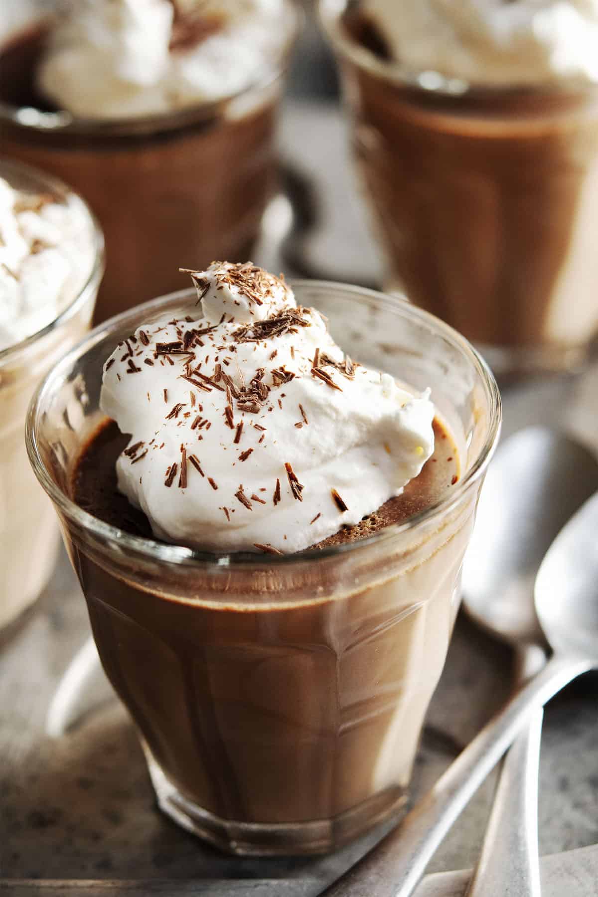 Chocolate Panna Cotta topped with whipped cream and served in glass tumblers