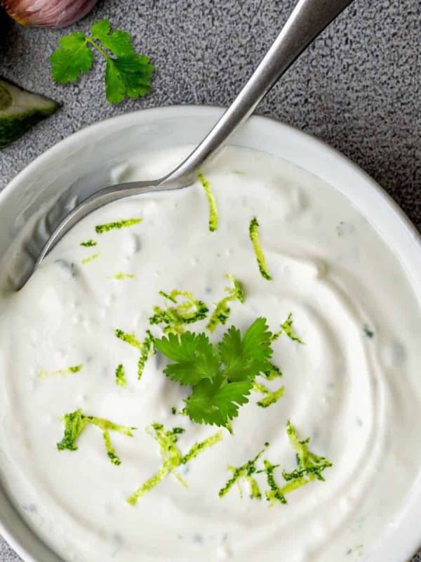 Cilantro Lime Crema served in a white bowl with a silver spoon.