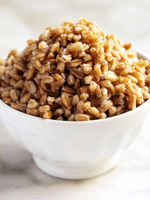 cooked farro piled in a white bowl