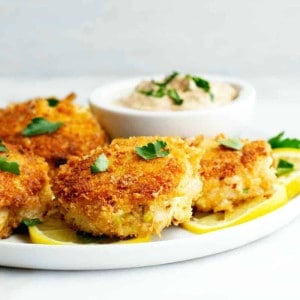 Crab-Cakes-served-on-a-white-plate-with-lemon-slices