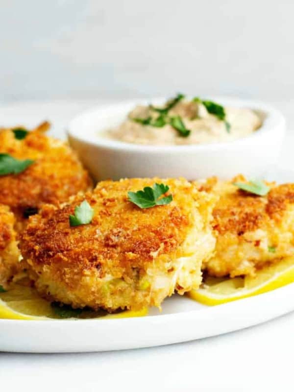 Crab-Cakes-served-on-a-white-plate-with-lemon-slices