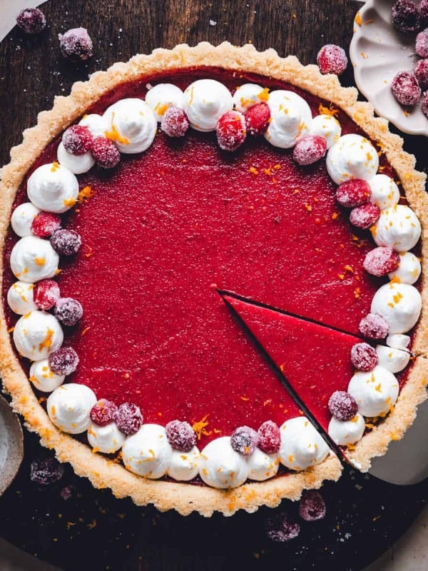 Lifting a single slice from a Cranberry Curd Tart photographed from the top.