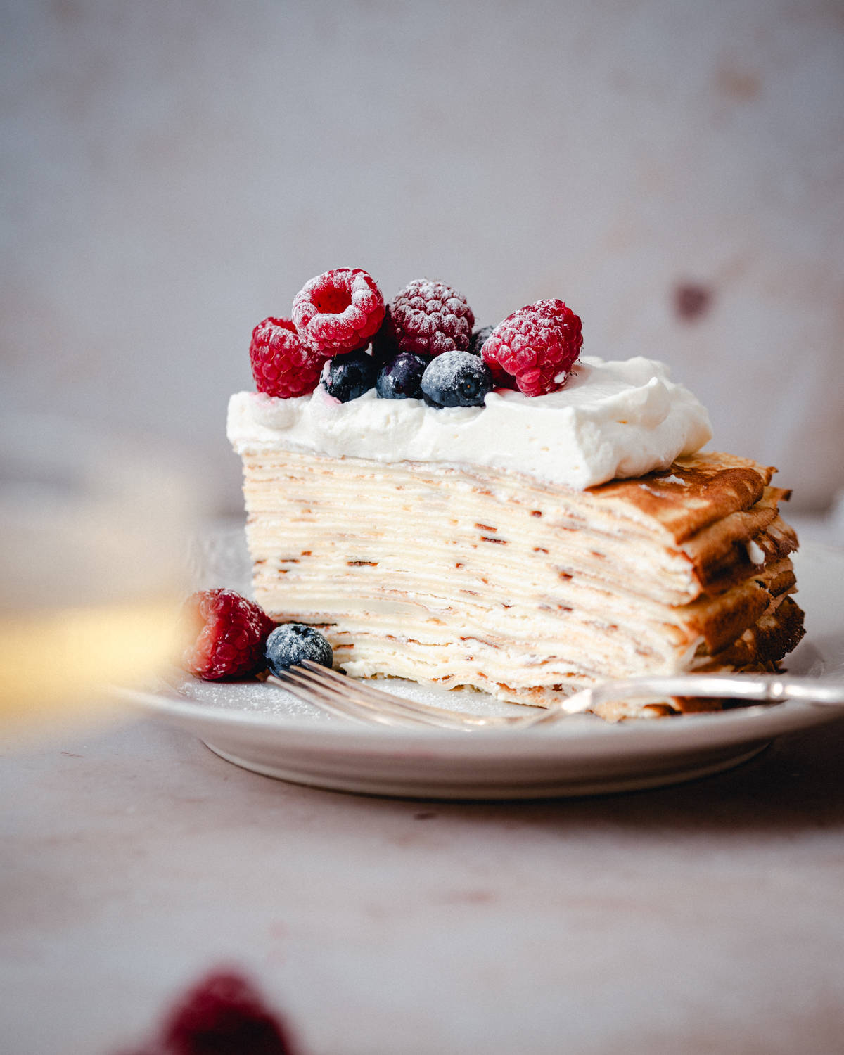 A slice of Crepe Cake on a white plate.