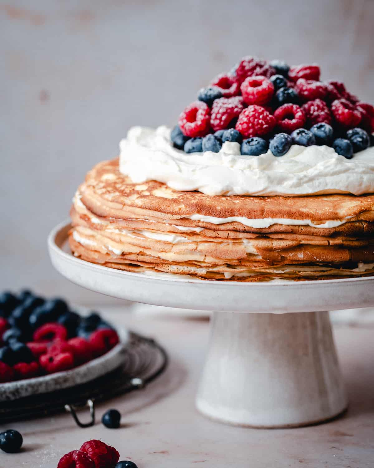 Crepe Cake served on a white ceramic cake stand.