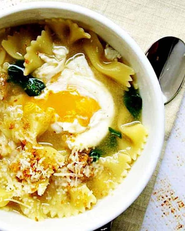 Egg-Farfalle-Bowtie-Pasta-Arugula-Soup served in a white bowl featured