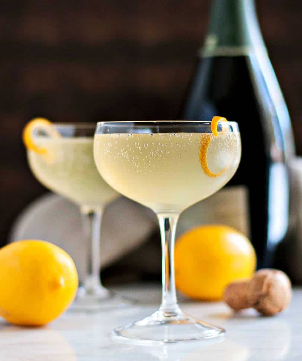 French 75 cocktails with lemons and Champagne in the background