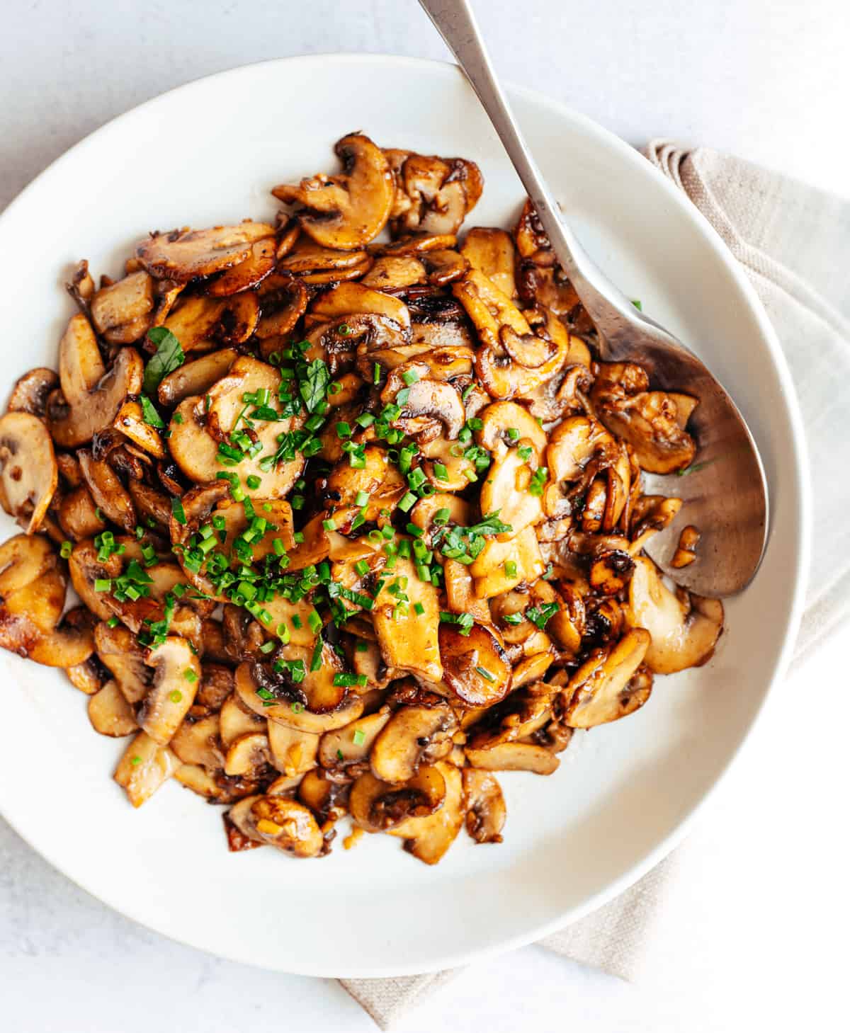 Garlic Butter Mushrooms served in a white bowl photographed from the top.