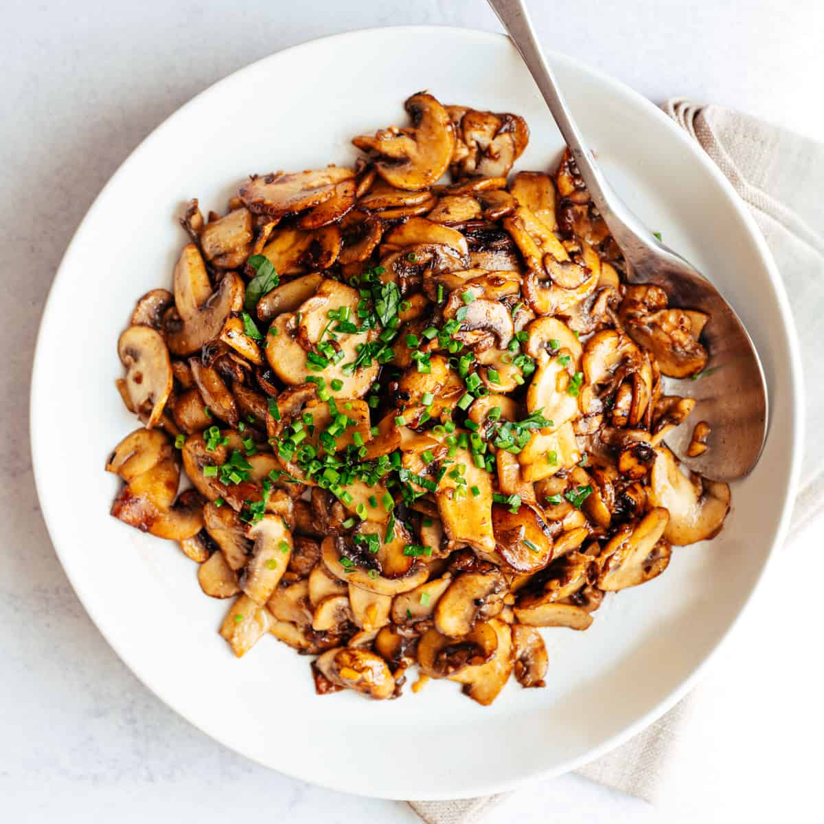 Garlic Butter Mushrooms served in a white bowl photographed from the top.