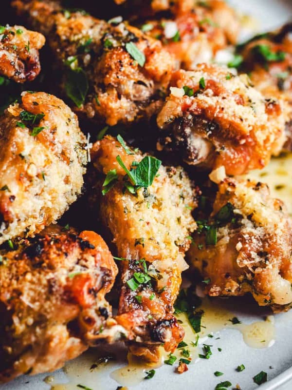 Garlic Parmesan Wings served on a light gray ceramic plate and photographed at an angle.