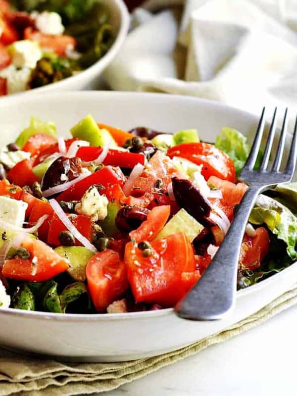 Greek-Salad served in white bowls featured