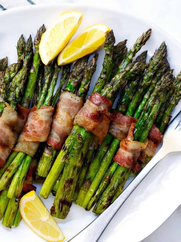 Grilled Bacon Wrapped Asparagus on a white platter