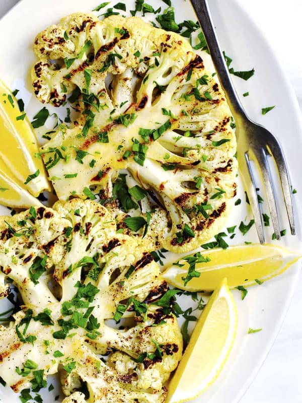 Grilled Cauliflower Steaks on a white oval platter