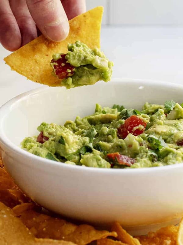 dipping guacamole with a tortilla chip