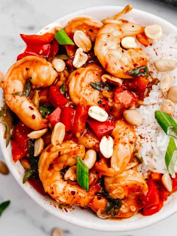 Kung Pao Shrimp served over rice in a white bowl and photographed from the top.