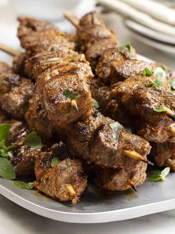 lamb kabobs served on a stainless platter