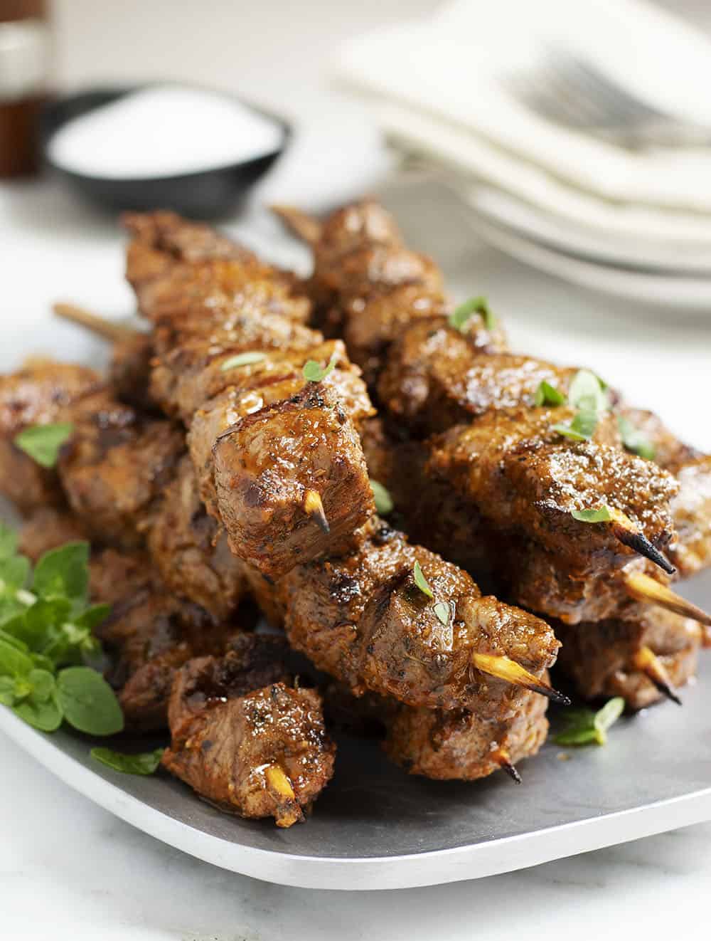 lamb kabobs served on a stainless platter