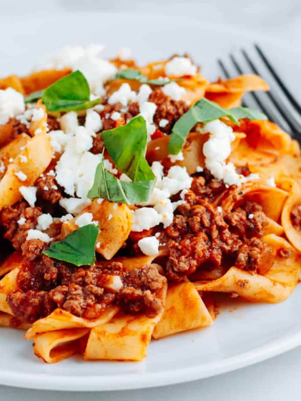 Lamb Ragu with pasta on a white plate.