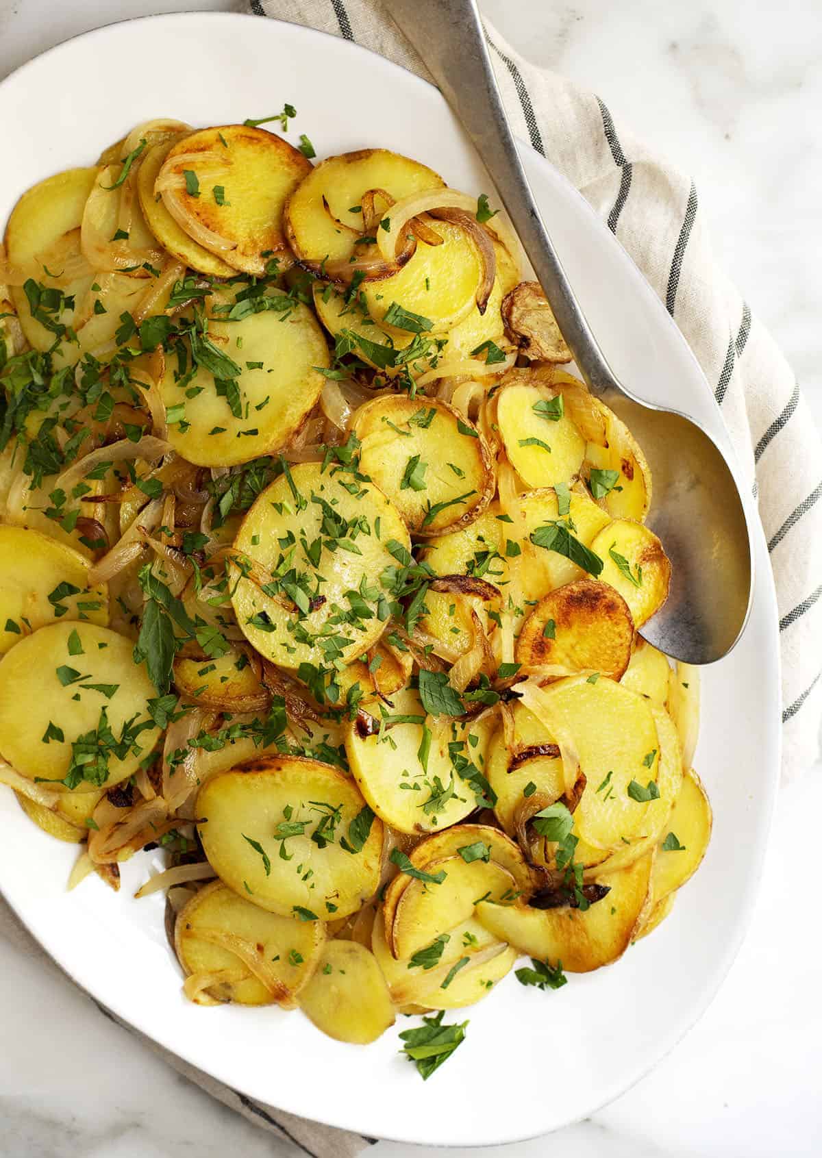 Lyonnaise Potatoes served on a white oval platter