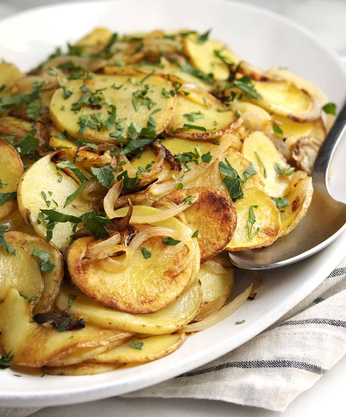 Lyonnaise Potatoes served on a white oval platter