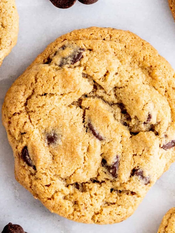 Oat Flour Chocolate Chip Cookies on a white marble board with scattered chocolate chips.