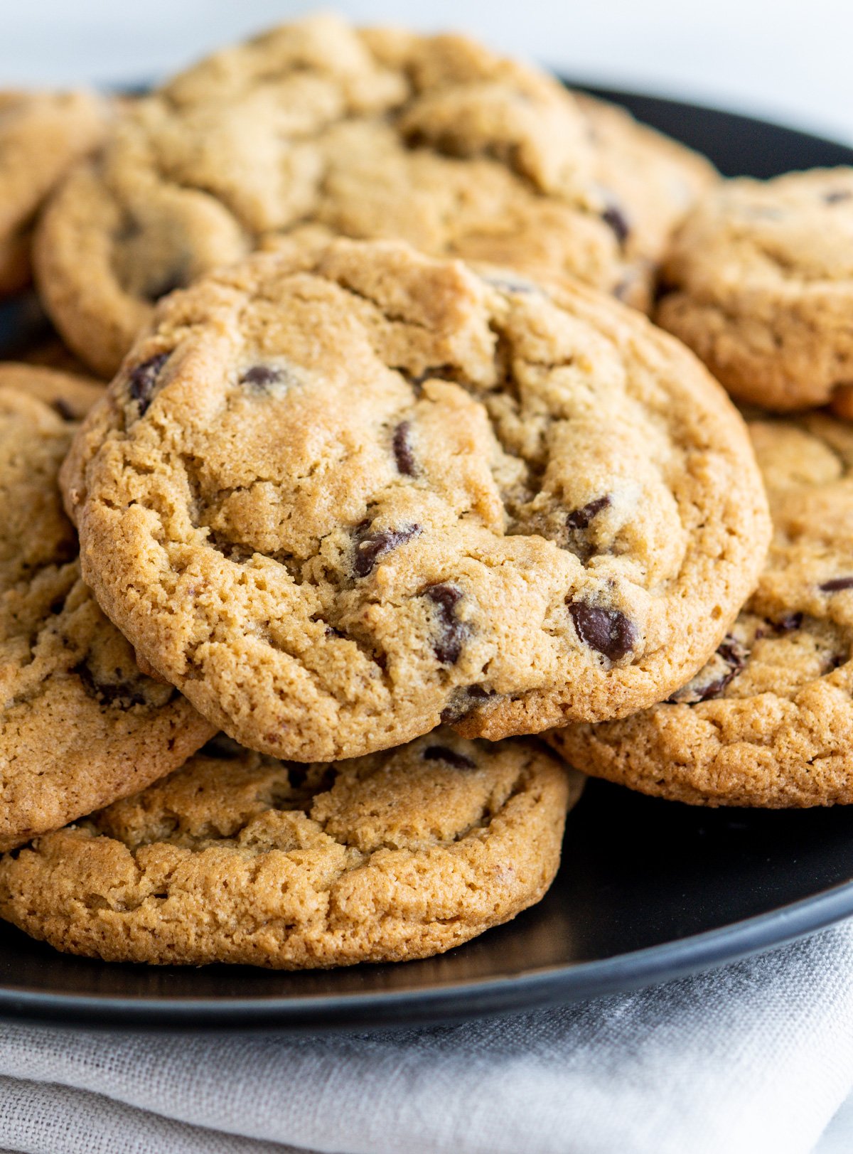 Oat Flour Chocolate Chip Cookies stacked on a black plate.