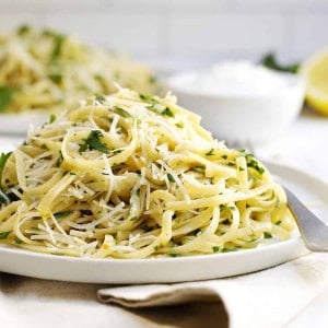 Pasta Aglio e Olio served on white plates with linen napkins