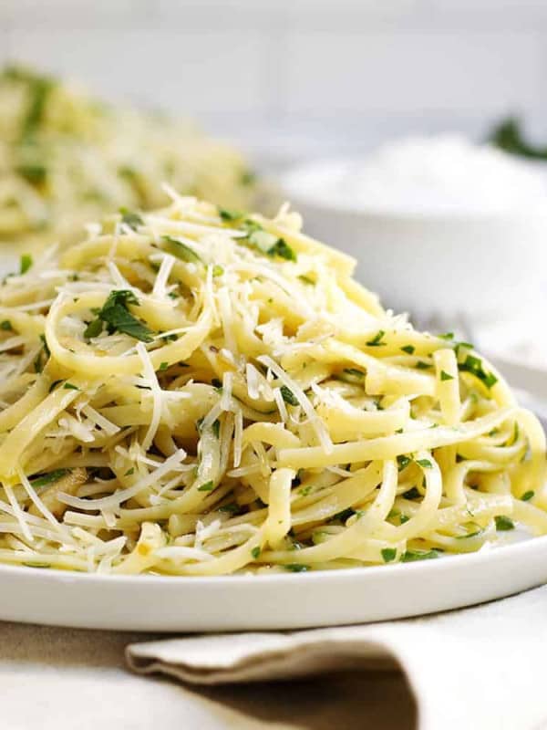 Pasta Aglio e Olio served on white plates with linen napkins