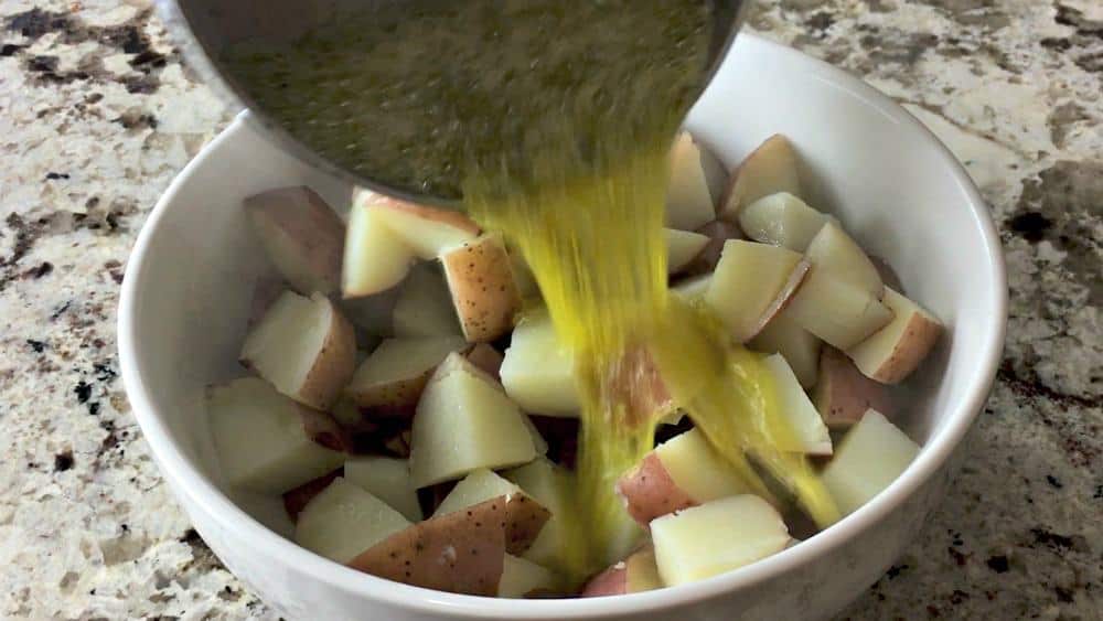 Pouring Olive Oil Mixture Over Tender Steamed Red Potatoes