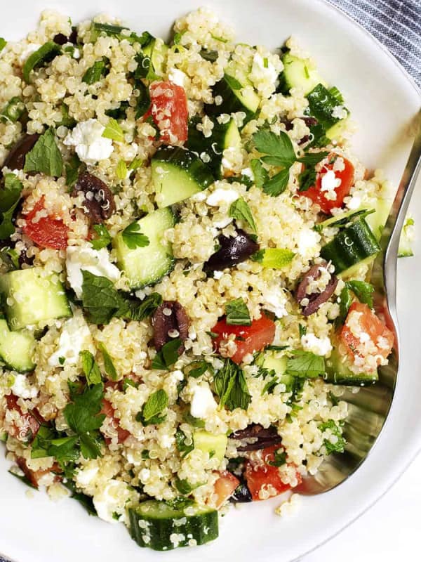 Quinoa Tabbouleh Salad served in a white bowl with stainless spoon