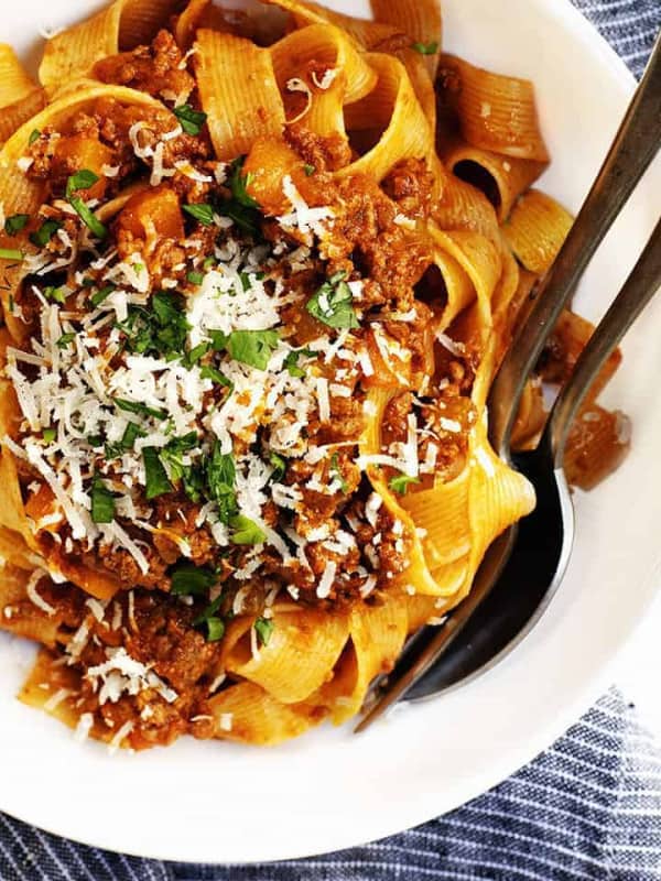 ragu sauce with pasta served in a white bowl