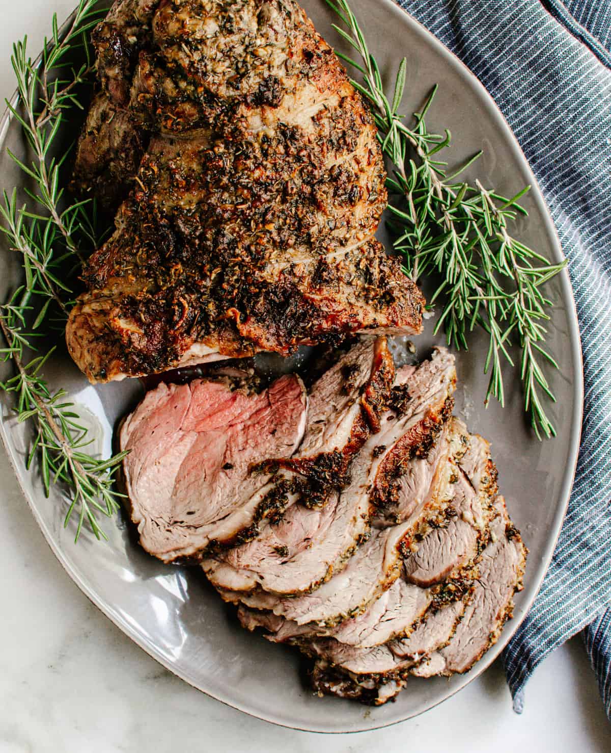 Roasted Boneless Leg of Lamb served on a gray oval platter.